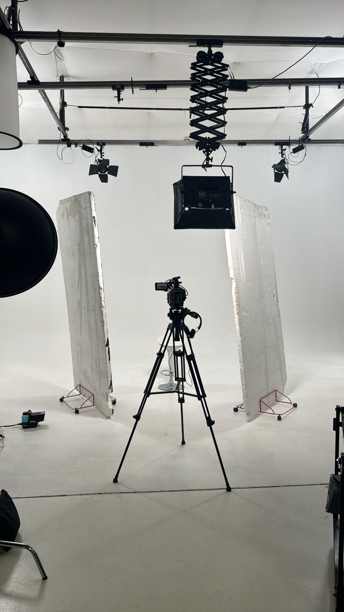 behind the scenes image in a professional studio with camera on show white studio background clean and aestetic 