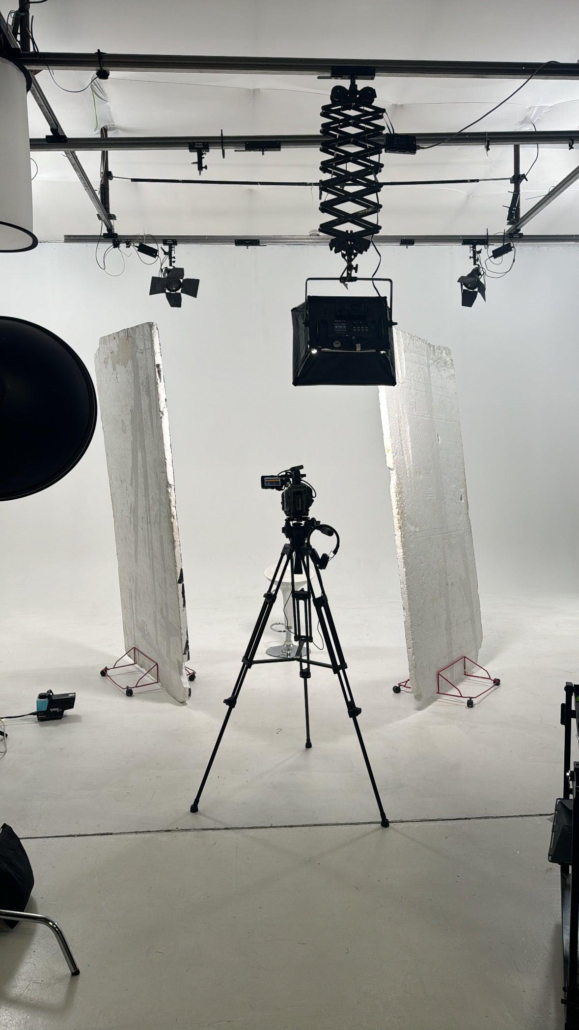 behind the scenes image in a professional studio with camera on show white studio background clean and aestetic 