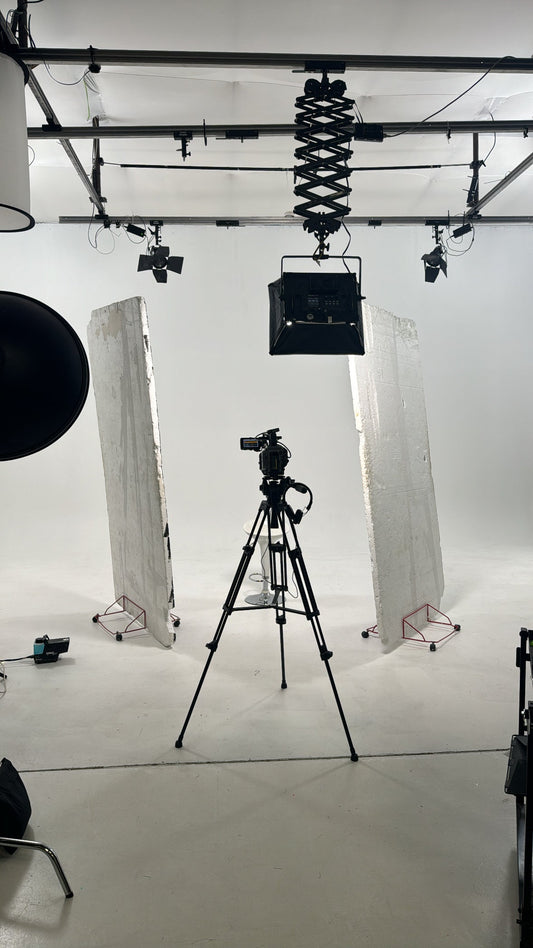 behind the scenes image in a professional studio with camera on show white studio background clean and aestetic 