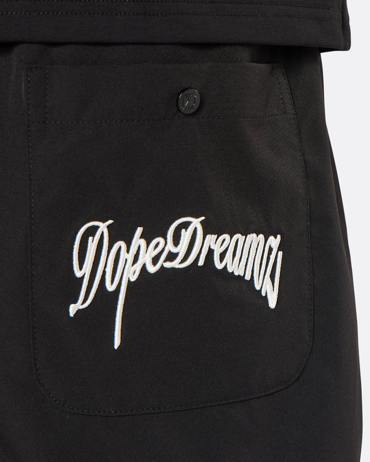 Close-up of the DopeDreamz Interlude Noir black premium shorts featuring the white embroidered DopeDreamz back pocket graphic and tonal DDZ metal button.