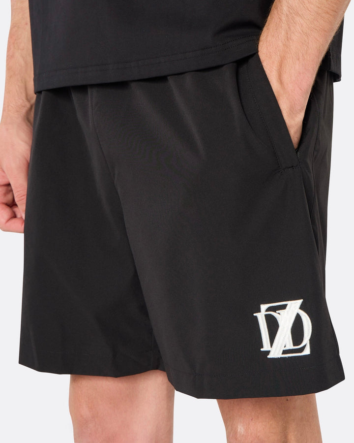 Close-up of the DopeDreamz Interlude Noir black premium shorts featuring the white embroidered DDZ logo and side pocket, three-quarter view.