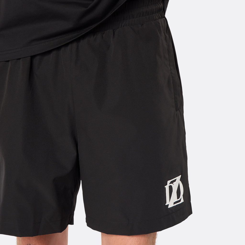 Close-up of the DopeDreamz Interlude Noir black premium shorts featuring the white embroidered DDZ logo.