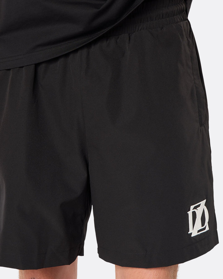Close-up of the DopeDreamz Interlude Noir black premium shorts featuring the white embroidered DDZ logo.