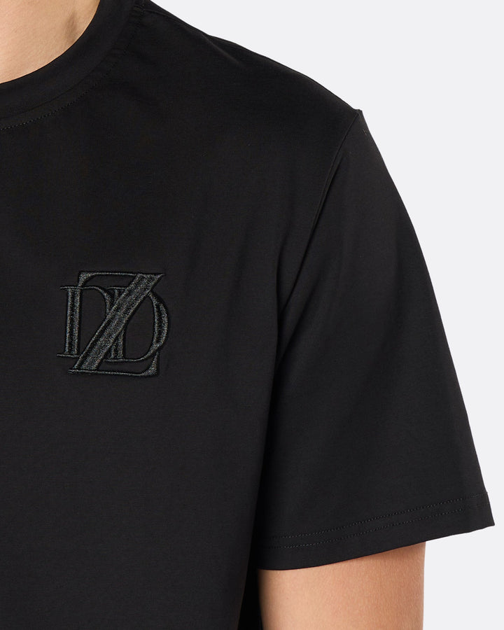 Close-up of the DopeDreamz Interlude Noir black premium T-shirt featuring the tonal black embroidered DDZ chest logo.
