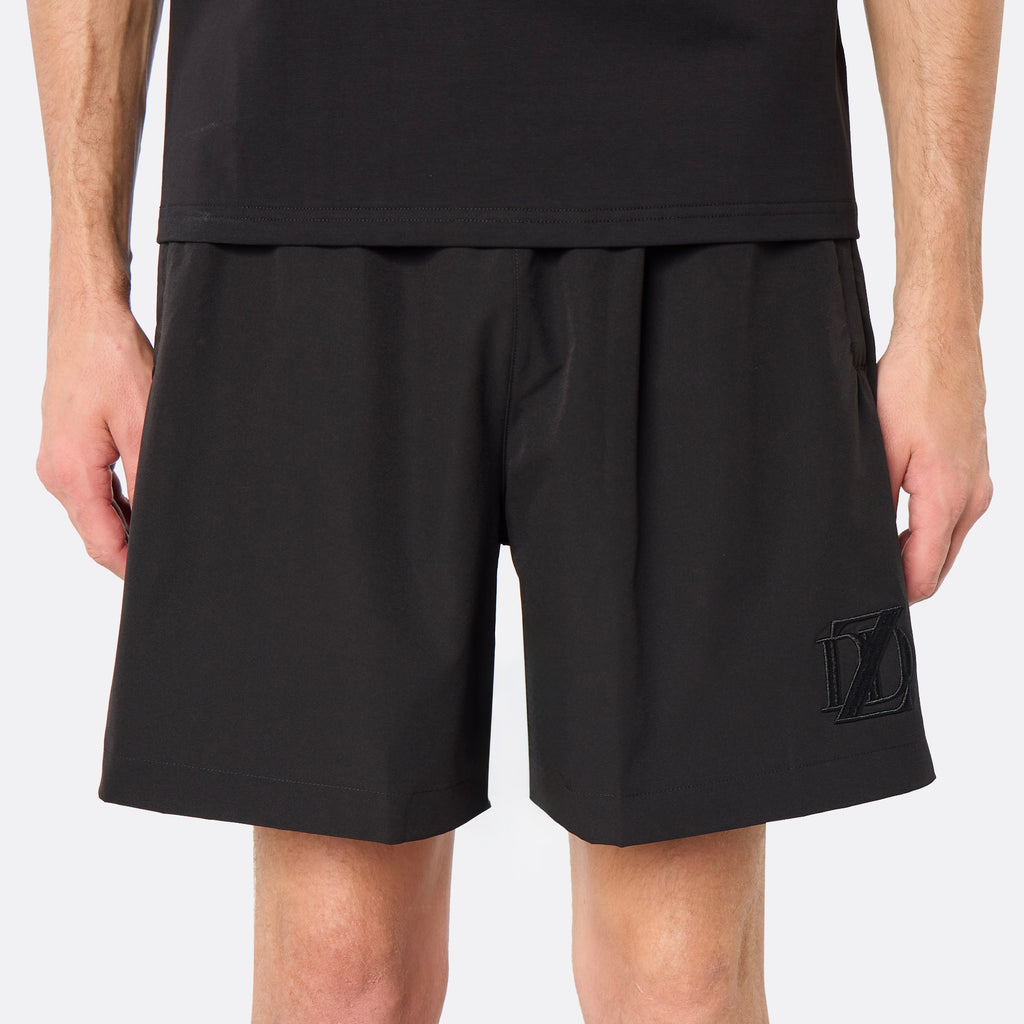 Front close-up of the DopeDreamz Interlude Noir black shorts featuring a tonal black embroidered DDZ monogram, concealed zip side pockets and a tailored, minimalist fit.