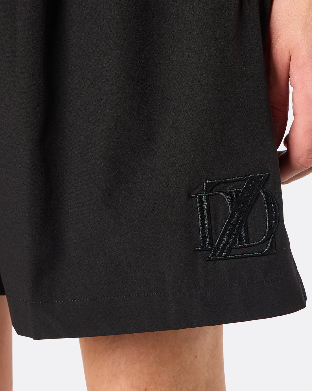 Detail close-up of the DopeDreamz Interlude Noir black shorts showcasing the premium tonal black embroidered DDZ monogram, finished with clean stitching and a minimalist design.