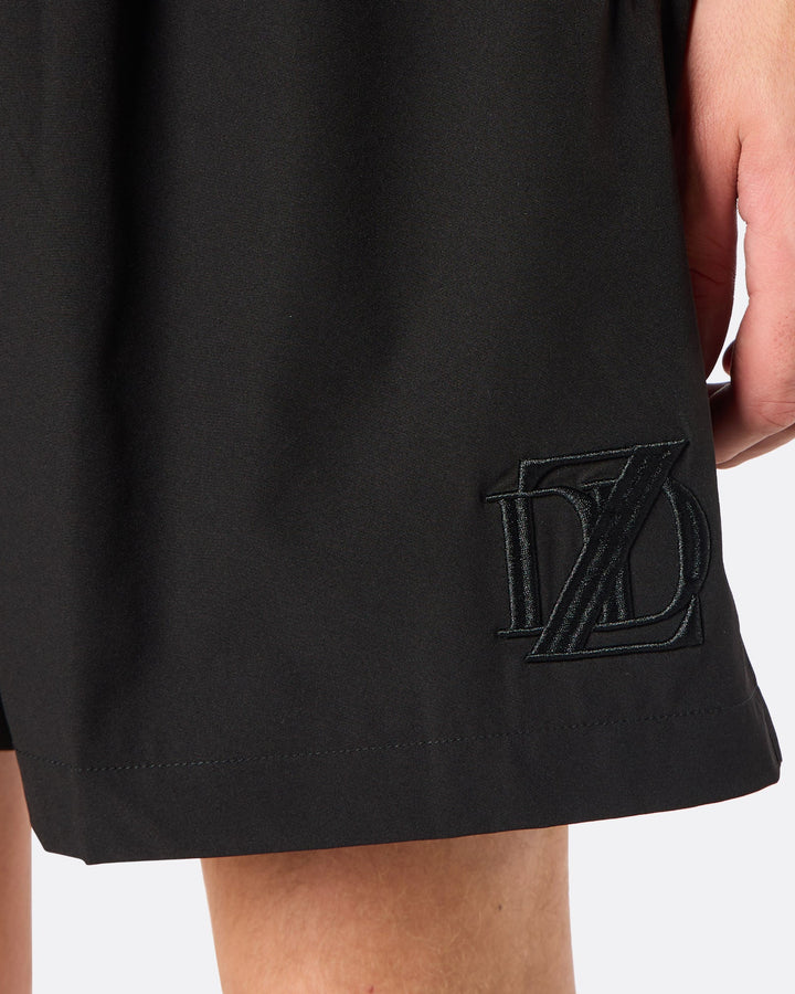 Detail close-up of the DopeDreamz Interlude Noir black shorts showcasing the premium tonal black embroidered DDZ monogram, finished with clean stitching and a minimalist design.