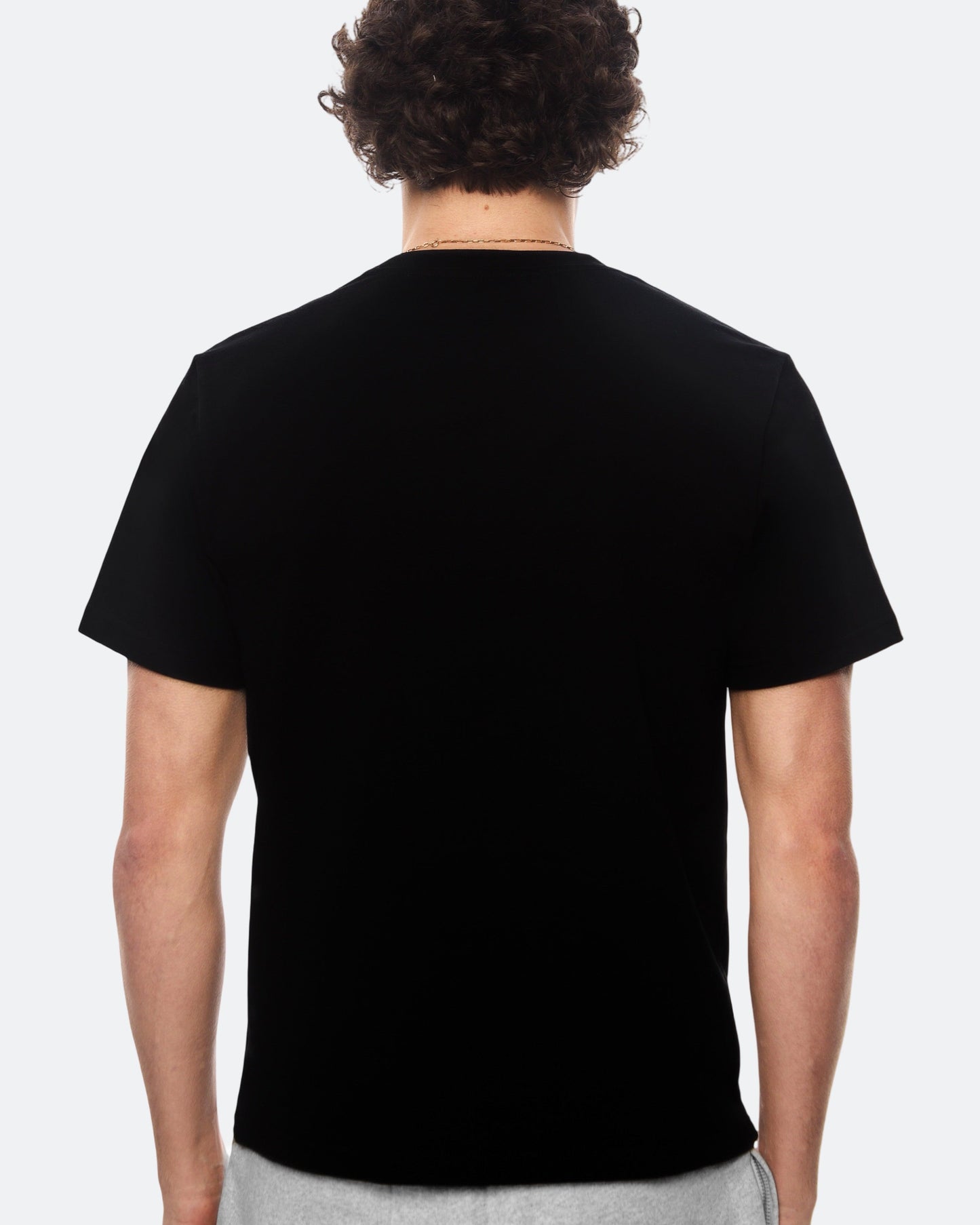 Back view of model wearing black DopeDreamz t-shirt on light background
