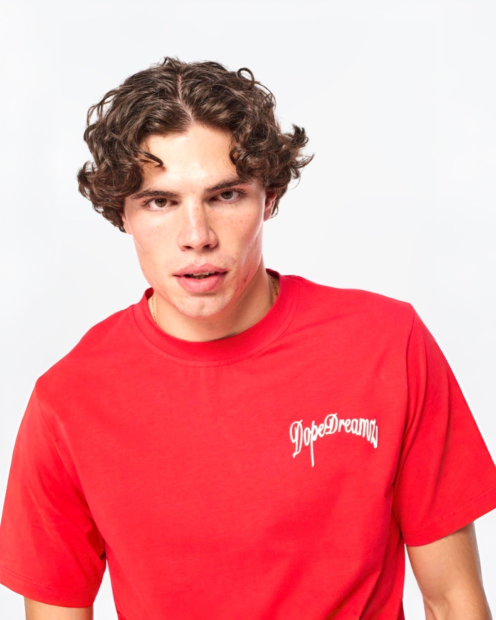 Close-up front view of red DopeDreamz t-shirt with 3D embroidered logo
