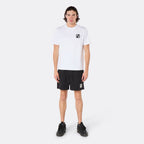 Male model wearing the DopeDreamz white Interlude Noir T-Shirt with black DDZ chest logo and black shorts, with white DDZ logo front view. Paragraph