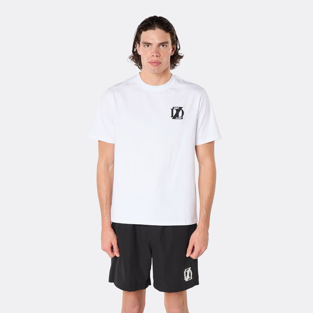 Male model wearing the DopeDreamz Interlude Noir white premium T-shirt with black DDZ chest logo and black shorts with white DDZ logo, close-up front view.