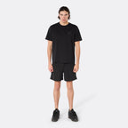 Male model wearing the DopeDreamz Interlude Noir black premium T-shirt with tonal black DDZ chest logo and black shorts with tonal black DDZ logo, front view.