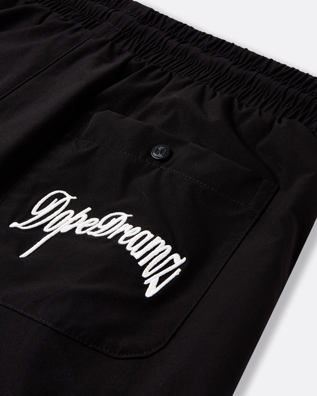     Black DopeDreamz Interlude Noir shorts detail of back pocket with white embroidered DopeDreamz logo and branded button