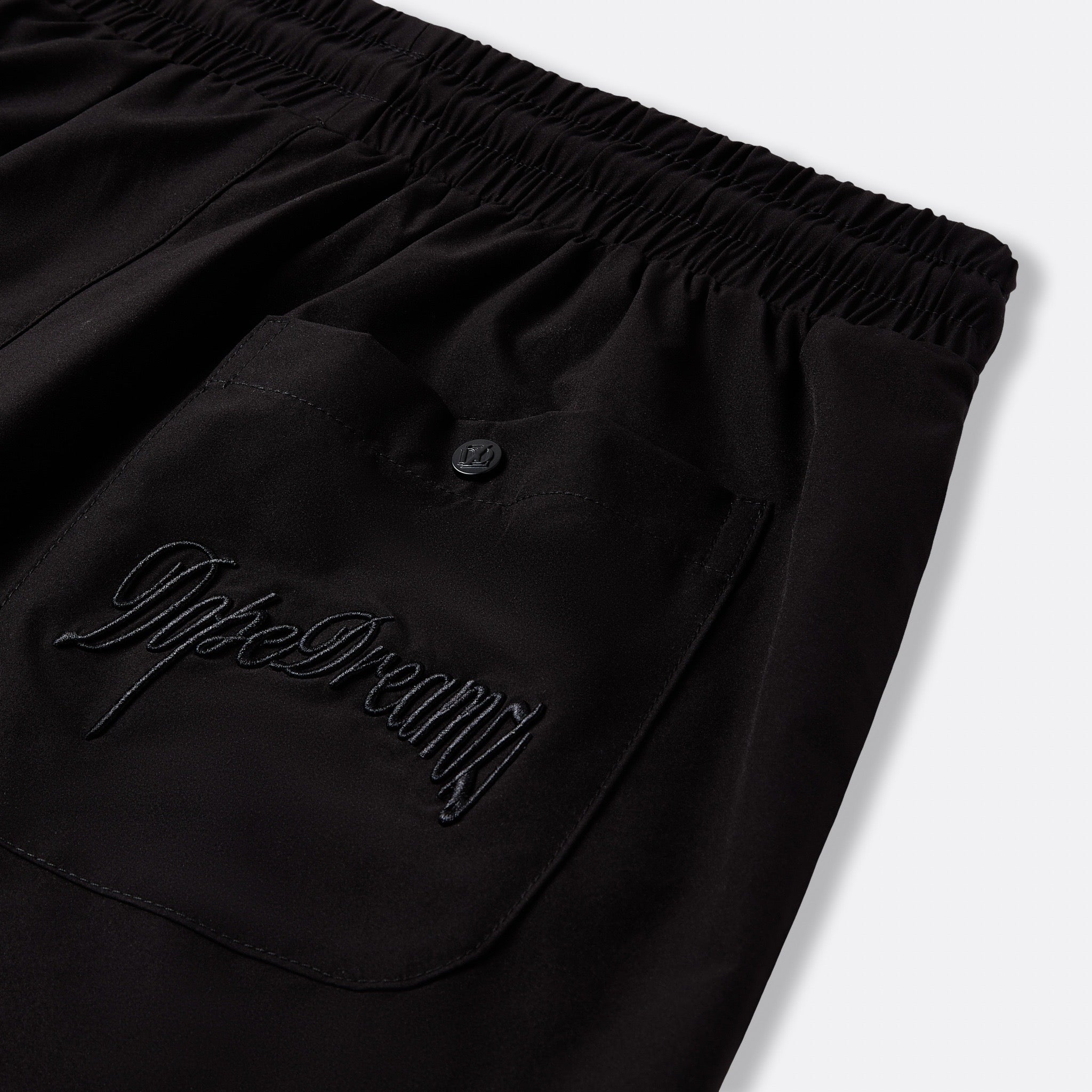 Black DopeDreamz Interlude Noir shorts detail of back pocket with embroidered DopeDreamz logo and branded button