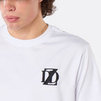 Close-up of a male model wearing the DopeDreamz Interlude Noir white premium T-shirt with black embroidered DDZ chest logo.