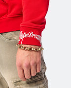 Close-up of white embroidered DopeDreamz logo on red hoodie sleeve cuff
