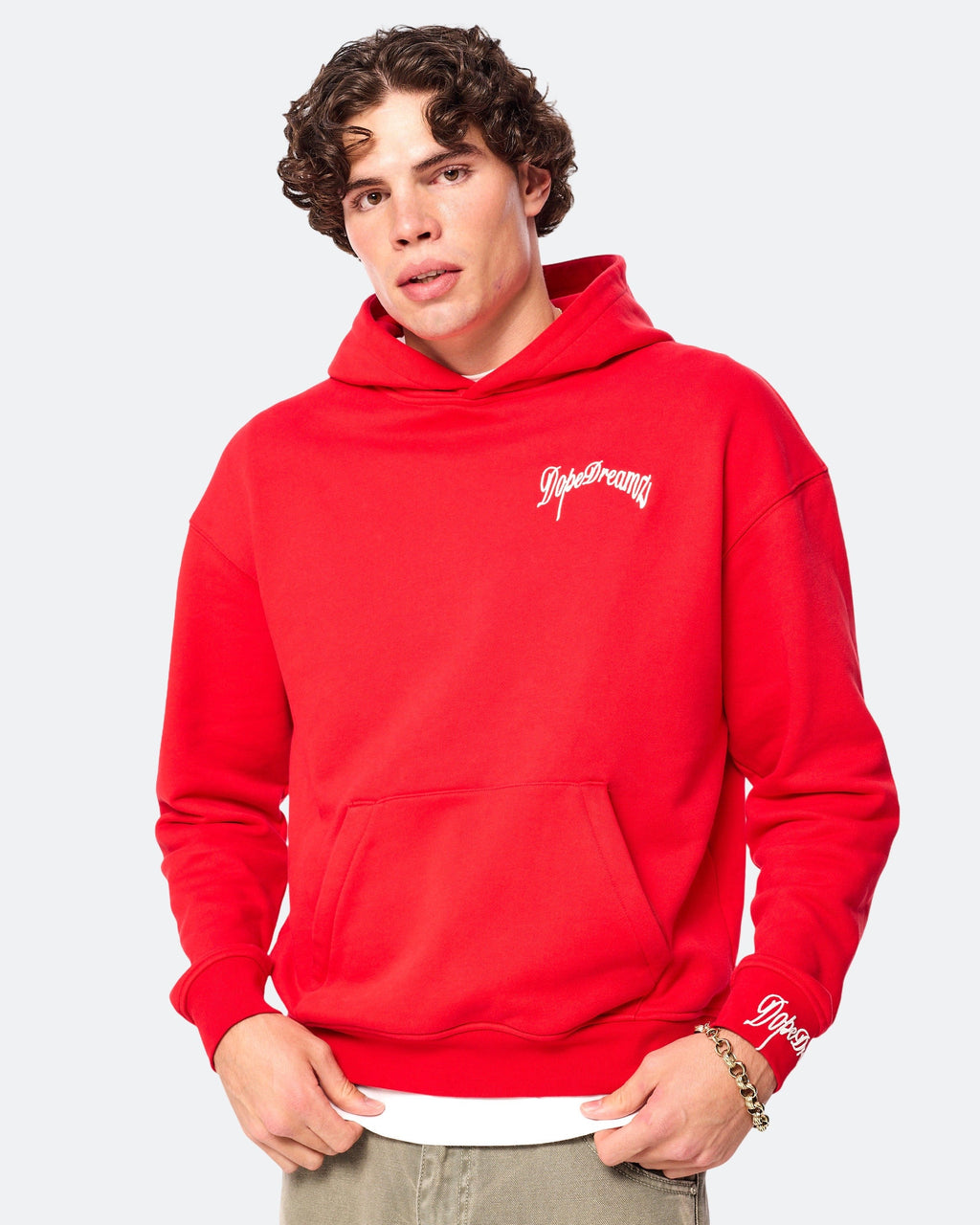 Model wearing red DopeDreamz hoodie with white embroidered chest logo, front view on white background
